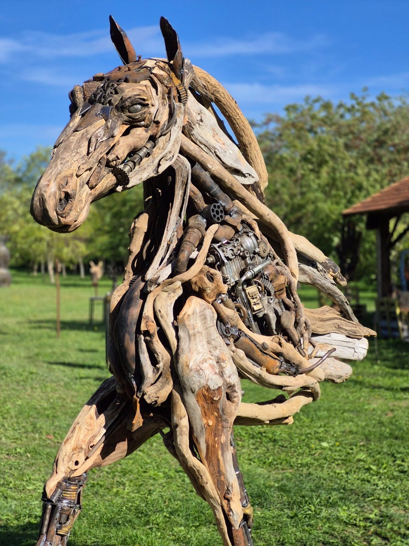 Romain Bresson : le sculpteur métal et son univers science-fiction Sculpture en bois flotté représentant un cheval dans un environnement extérieur.