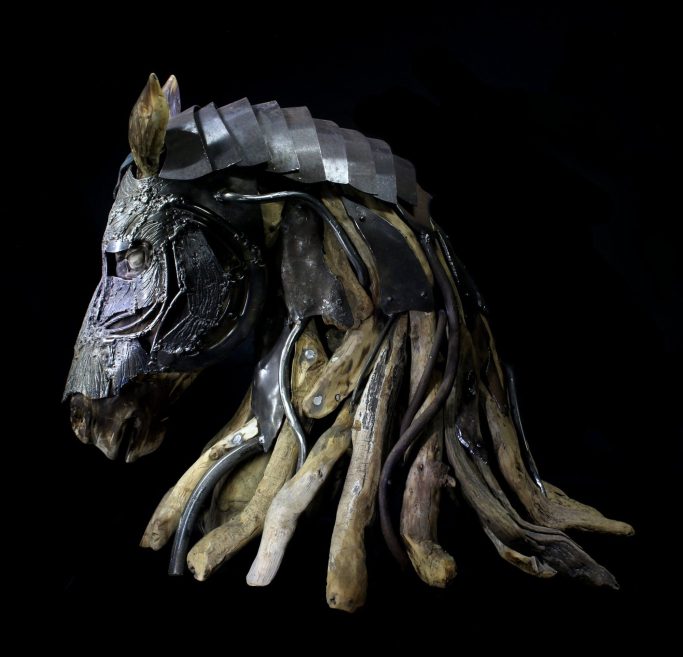 Romain Bresson : le sculpteur métal et son univers science-fiction Statue en métal rouillé représentant une figure humaine avec des détails ornementaux.
