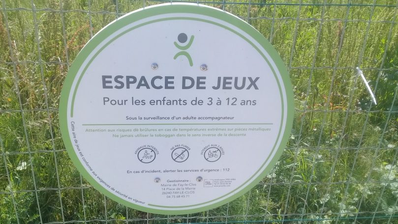 Panneau indiquant un espace de jeux pour enfants de 2 à 12 ans.